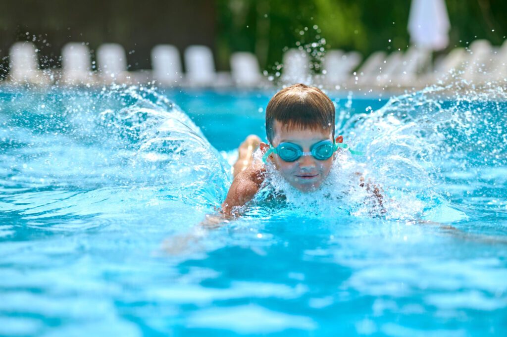 Comment apprendre le crawl : un enfant nage dans une piscine