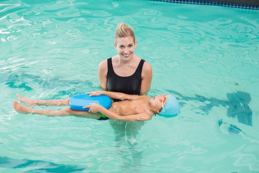 Apprendre à flotter : une maître nageuse apprend à un enfant à flotter