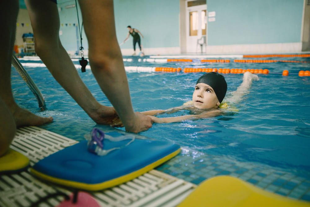 Brasse avec pull-buoy : un enfant nage dans une piscine