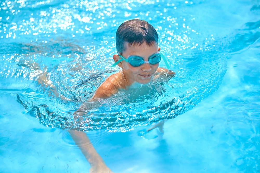 Brasse avec pull-buoy : un enfant nage dans une piscine