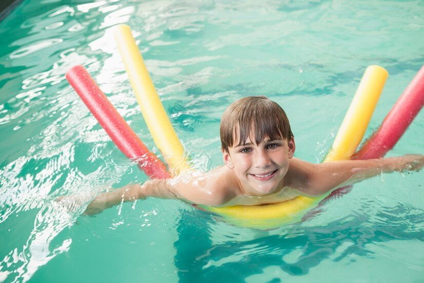 Comment apprendre à nager sur le ventre : un enfant nage sur le ventre avec des frites