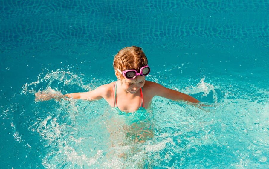 Une enfant nage après avoir effectué un plongeon canard