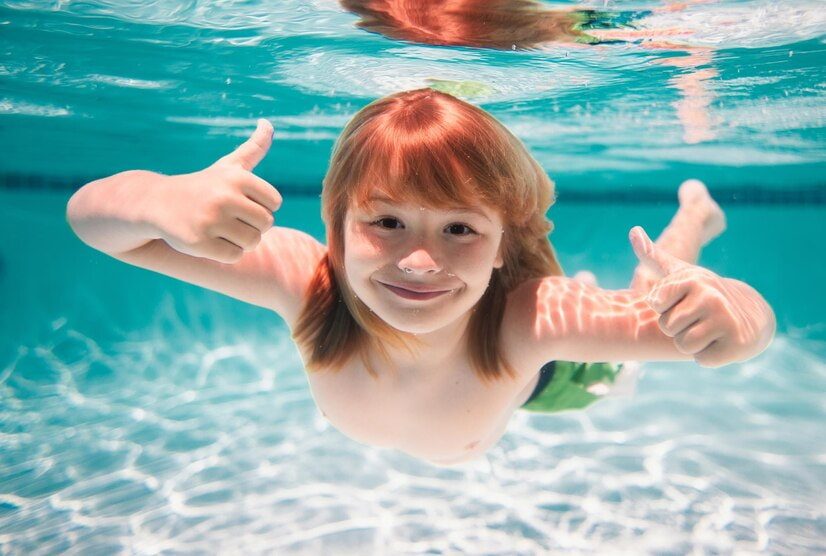 Comment apprendre à nager sur le ventre : une enfant nage dans une piscine